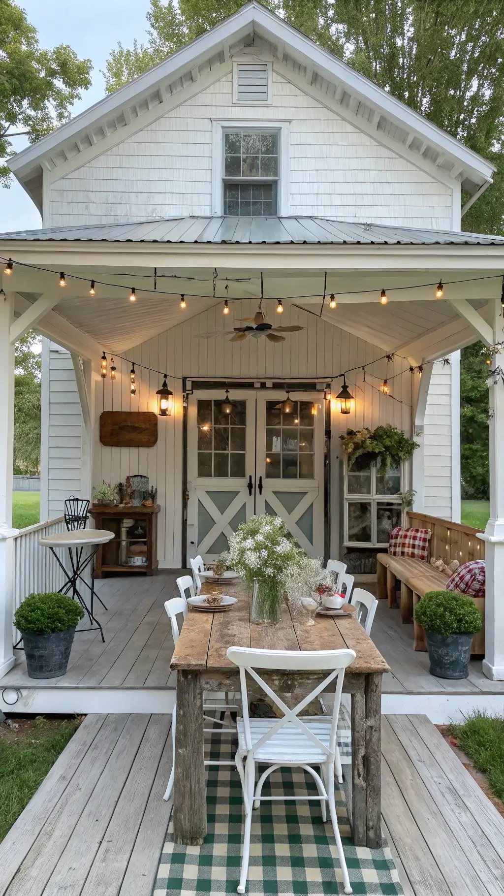 Whitewashed 16x16ft farmhouse gazebo hosting vintage enamelware and mason jar arrangements on distressed wooden dining set, with buffalo check cushions and galvanized metal accents under market lights strung in X-pattern overhead, captured from entrance featuring charming Dutch door.